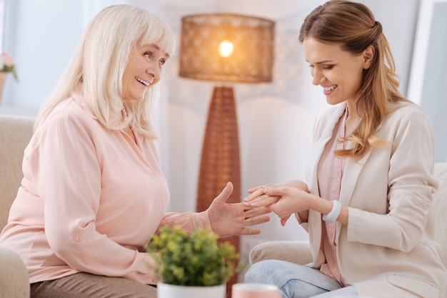 My congratulations. Nice joyful elderly woman smiling and looking at her daughter while congratulating her on the engagement