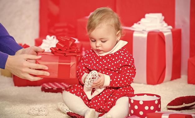 My first christmas Sharing joy of baby first christmas with family Baby first christmas once in lifetime event Little baby play near pile of wrapped red gift boxes Gifts for child first christmas