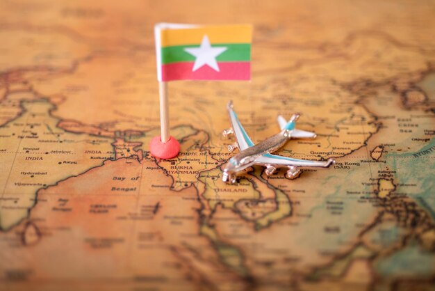 Photo myanmar flag and airplane on the world map