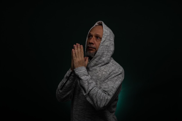 Mysterious man wearing hooded sweatshirt making hand gestures