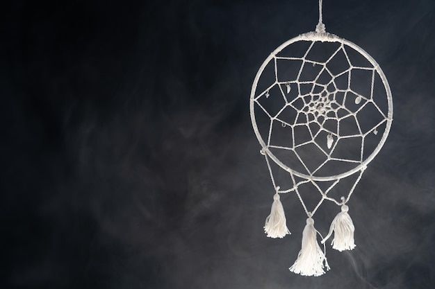 Mystical attribute dreamcatcher on a black background with smoke