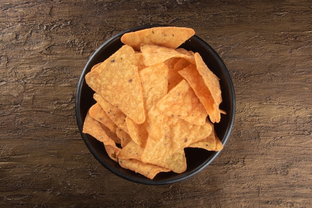 Nachos in a black bowl top view.