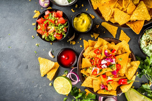 Nachos chips with various  dips, traditional mexican snack on plate