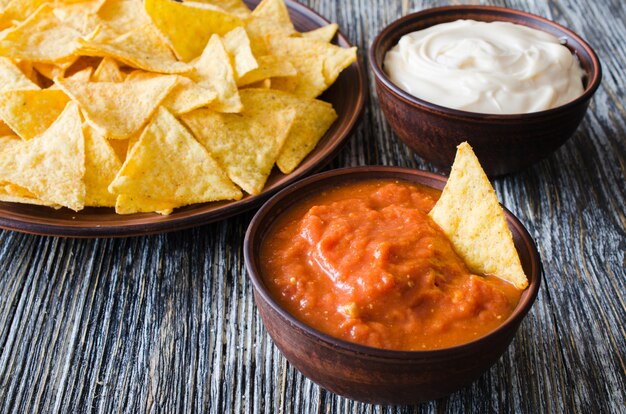 Photo nachos corn chips with spicy tomato and cheese sauces.