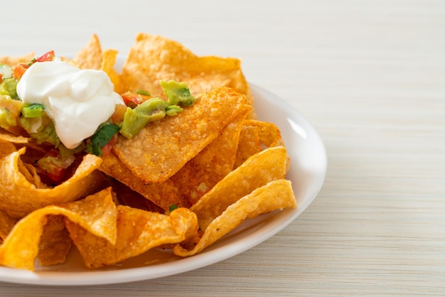 Nachos tortilla chips with jalapeno guacamole tomatoes salsa and dip