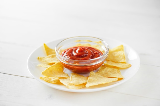 Photo nachos with tomato salsa on white plate selective focusxa