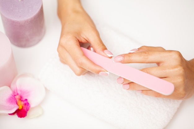 Nail care, woman with beautiful hands doing manicure in beauty studio