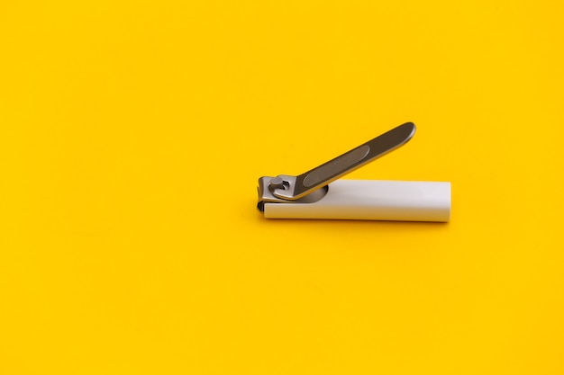 Nail clippers on a yellow background close-up