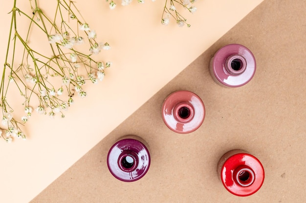 Nail polish of different colors in glass tubes stands on a light background