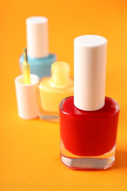 Nail polish on orange background, close up