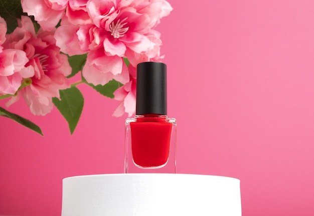 Nail polish small glass bottle on podium Unbranded mockup on pink background with copy space