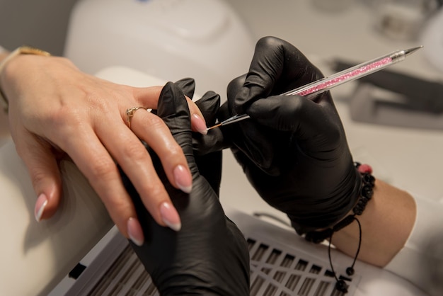 Nail salon workplace of a manicurist manicurist paints nails to a client