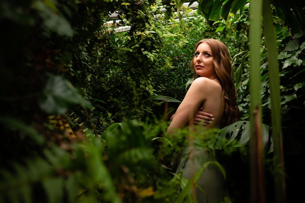 Photo naked girl model in the tropical forest curly hair professional makeup