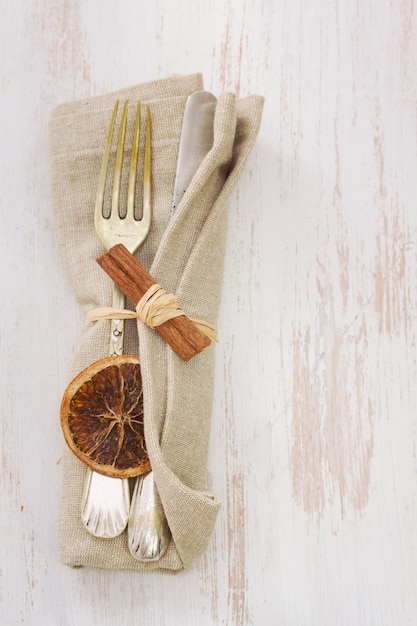 Napkin with fork and knife on white wood