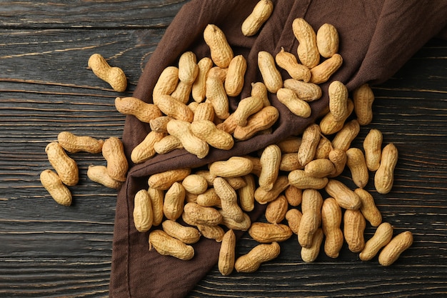 Napkin with peanuts on wooden background