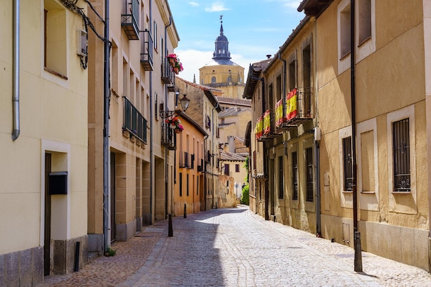 Narrow alley with old houses and view of the cathedral of Segovia in the background Spain