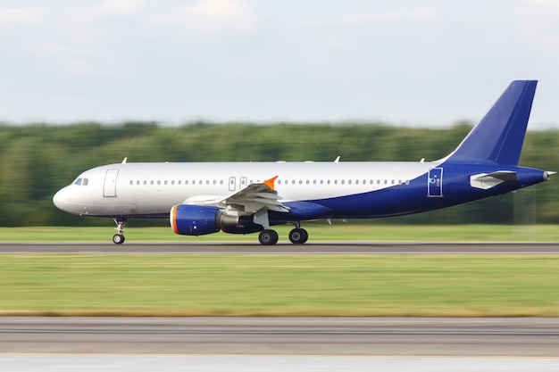 Narrow-body passenger airplane taxing on runway for take off, side view, in motion