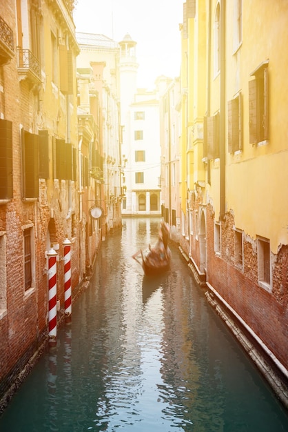 Photo narrow canal with gondolas in venice italy