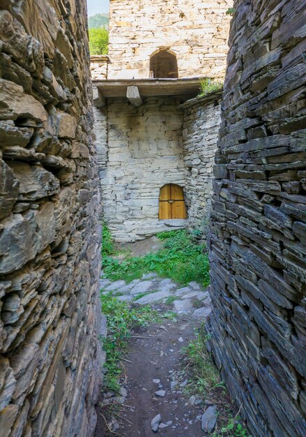 Photo narrow passage to the tower window between the walls streets of medieval village shatili