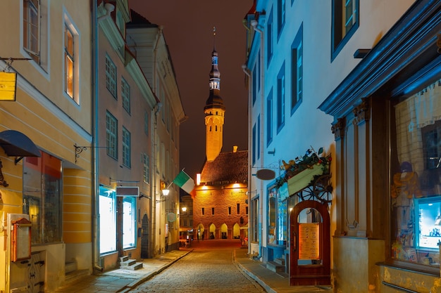 Narrow street illuminated of Old Town at night City Hall on the background Tallinn Estonia