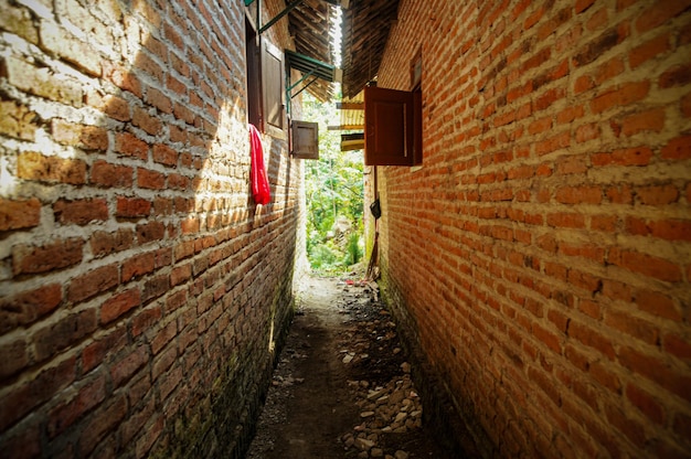 A Narrwo path in a small town between two brick wall of the houses