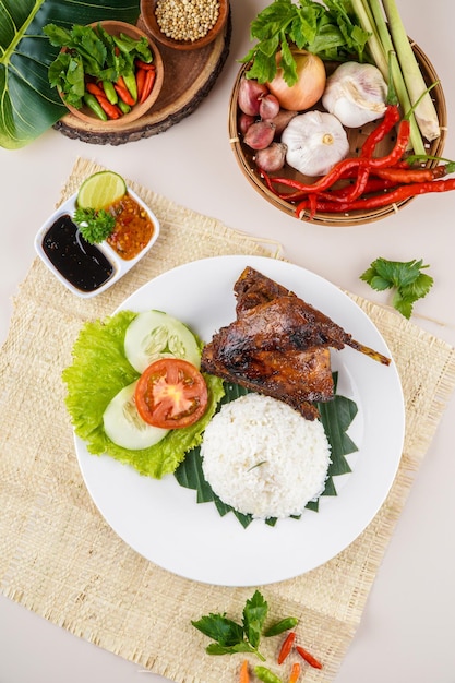 Nasi Bebek Bakar or Roasted duck with Sambal Terasi, a traditional food from Indonesia.