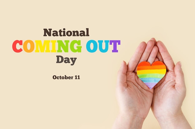 National coming out day Stop Homophobia Heart with rainbow LGBT flag in the hands