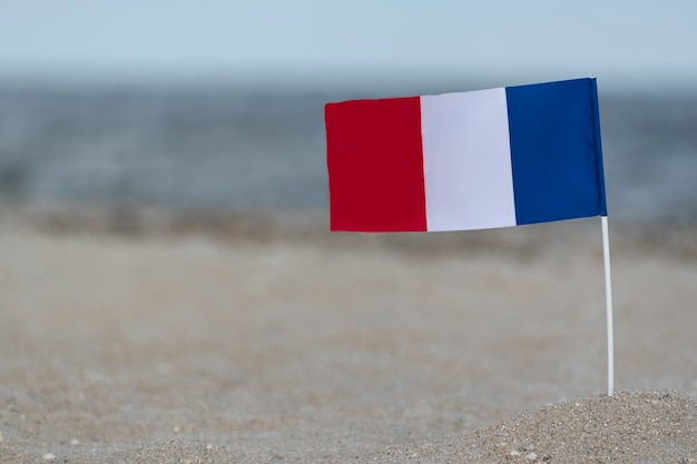 National flag of France on sea sand