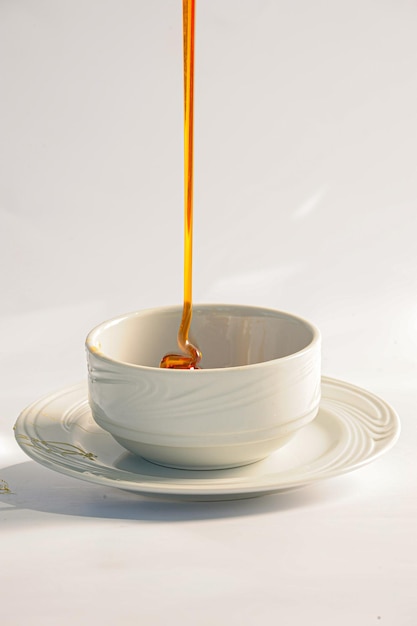 In natura honey being poured into a white pot just produced