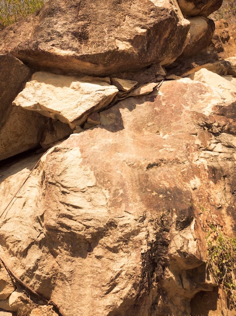 Natural background Closeup edged shabby cliff cracks Graybrown stone rock texture of mountains Vintage and faded matt style colour in tinted photo Concept of geolog mountaineering or hard work