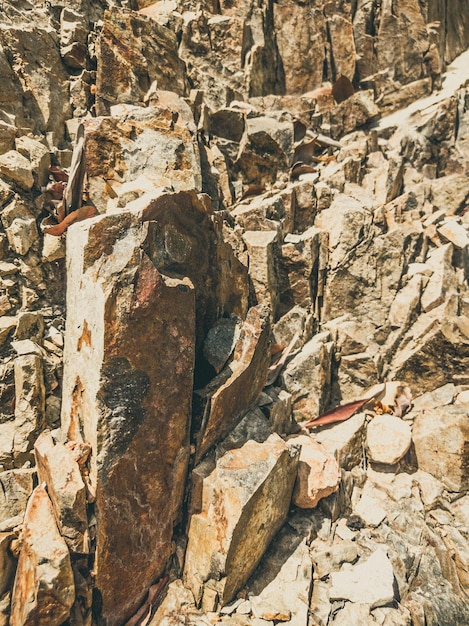 Natural background Closeup edged shabby cliff cracks Graybrown stone rock texture of mountains Vintage and faded matt style colour in tinted photo Concept of geolog mountaineering or hard work