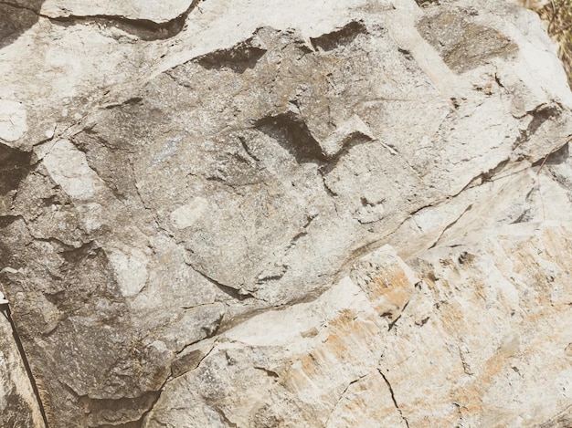 Natural background Closeup edged shabby cliff cracks Graybrown stone rock texture of mountains Vintage and faded matt style colour in tinted photo Concept of geolog mountaineering or hard work