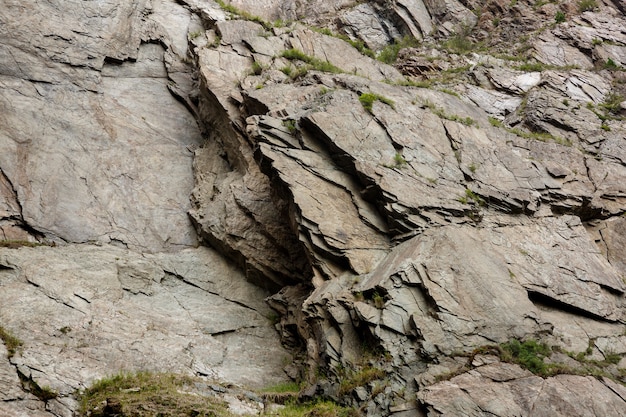 Natural background  stone rock of gray color with green grass