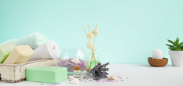 Natural bath Soaps for aromatherapy and body care . Lavender Spa treatment, towels, sea salt and dried herbs. Aromateraphy and spa mint background banner.