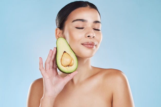 Natural beauty product woman skincare wellness and avocado fruit for sustainable face skincare Food hair mask health nutrition vegetable diet lifestyle and cosmetic blue background portrait