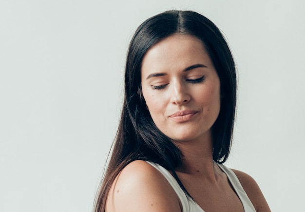 Natural brunette woman long hair casual makeup. Studio shot.