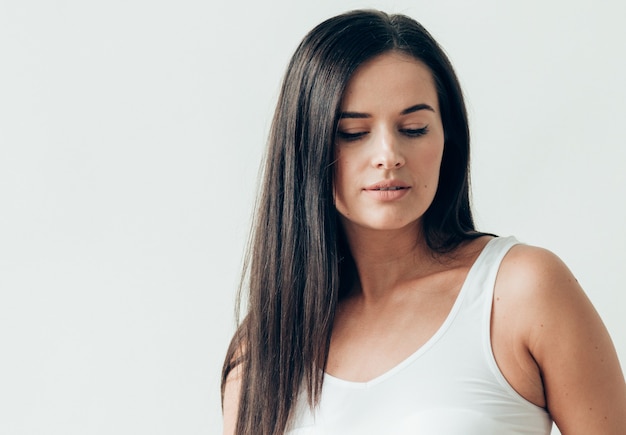 Natural brunette woman long hair casual makeup. Studio shot.