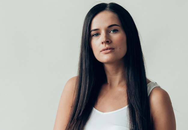 Natural brunette woman long hair casual makeup. Studio shot.