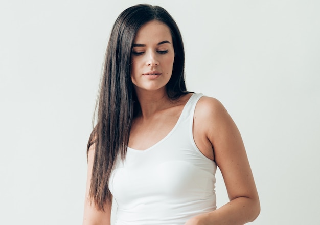 Natural brunette woman long hair casual makeup. Studio shot.