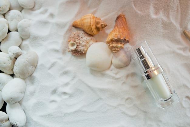 natural cosmetics bottle container on sand with Shell, empty bottle