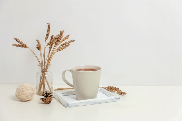 Natural eco home decor with cup coffee candle on wooden tray. Early morning breakfast lifestyle background. Interior decoration with hot drink mug. Hygge scandinavian style concept copy space