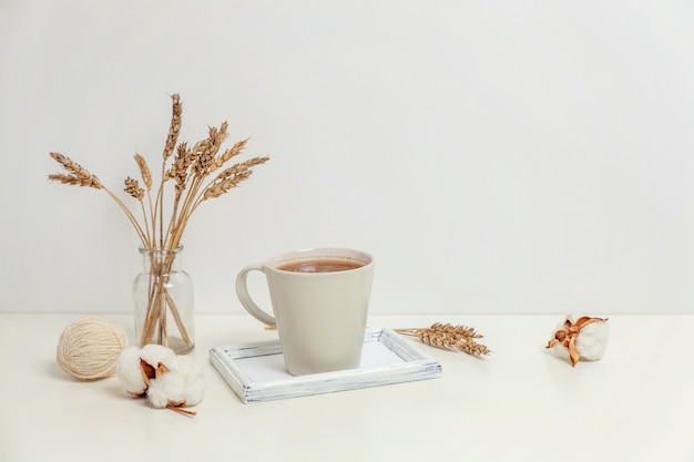 Natural eco home decor with cup coffee candle on wooden tray. Early morning breakfast lifestyle background. Interior decoration with hot drink mug. Hygge scandinavian style concept copy space