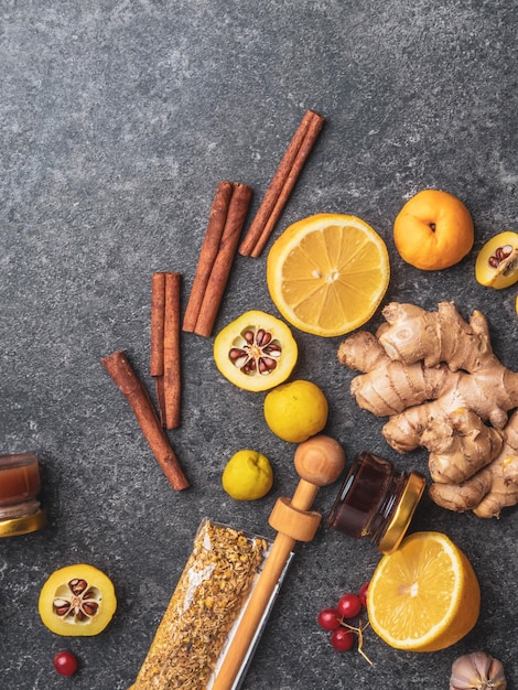 Natural flu and cold remedy ingredients chamomile flowers cinnamon sticks ginger lemon honey cydonia propolis garlic Flat lay