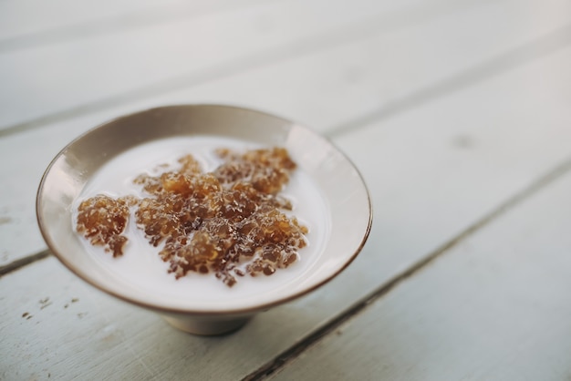 Natural food concept: Sago starch from plants in Thailand in a cup of coconut milk, set on a white background.