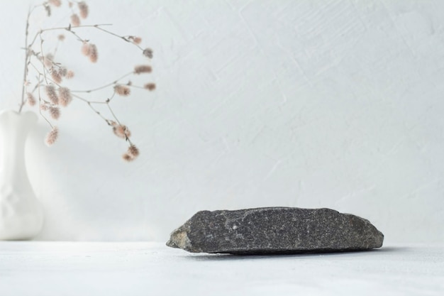 Natural grey stone and floral arrangement in a vase minimalistic background for product display