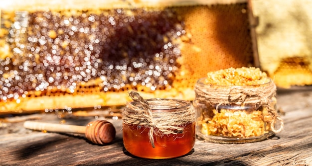 Natural honey with a spoon on old rustic table bee products by organic natural ingredients concept closeup