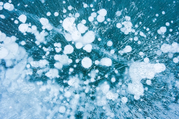 Natural ice bubbles on frozen lake in wintertime