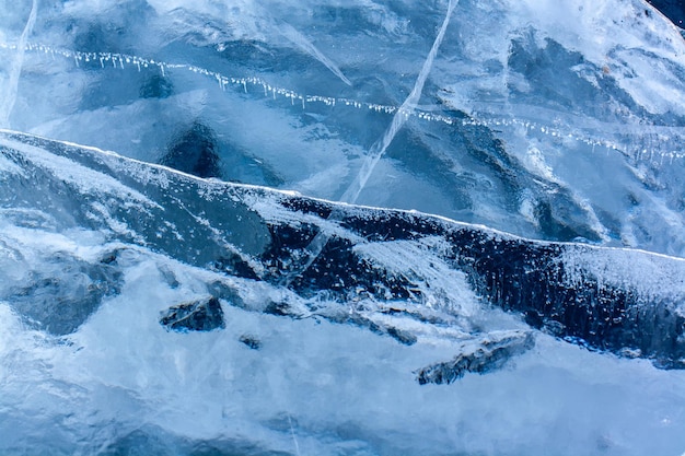 Natural ice texture with cracks and air bubbles thick blue transparent ice horizontal