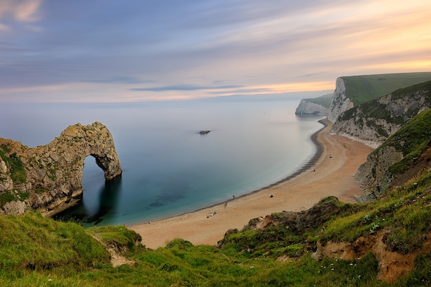 Natural limestone arch Durdle Door on Jurassic coastline of Dorset in England at sunset