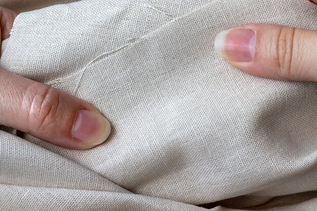 Natural linen fabric in female hands.